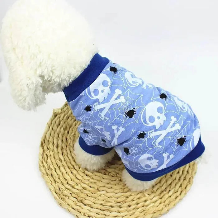 Blue Halloween dog shirt with skulls, spiders, and webs on fluffy white pup