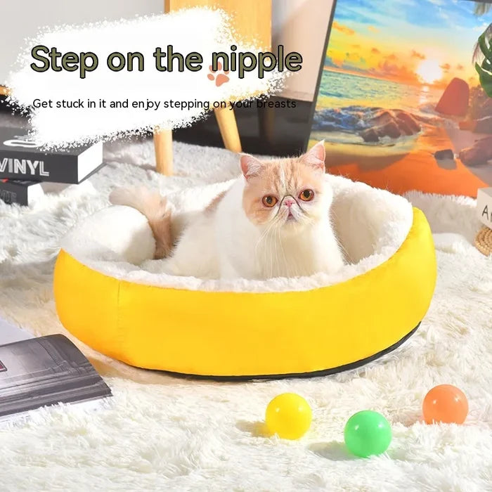 Fluffy cat in cozy yellow banana-shaped pet bed with colorful balls, perfect for cat comfort and play