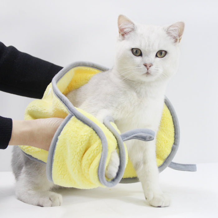 White cat wearing a yellow soft protective grooming restraint suit.