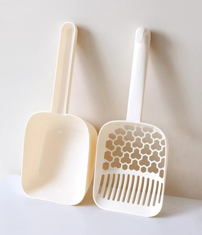 White and cream cat litter scoops with honeycomb slats for pet waste cleanup