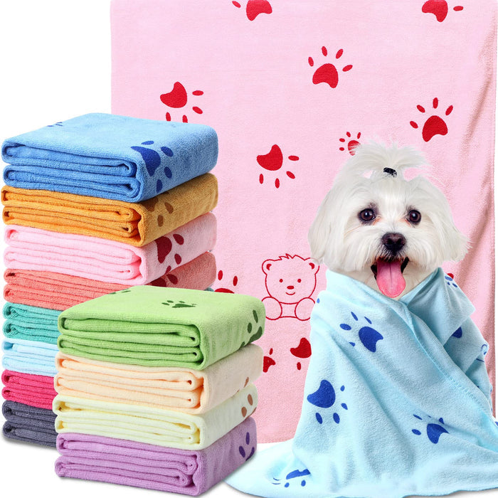 Stack of colorful microfiber pet towels and a small white dog wrapped in a blue paw print towel.