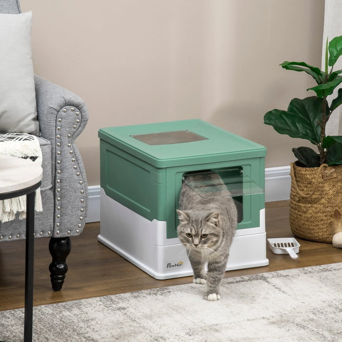 Gray tabby cat exiting green and white enclosed litter box in cozy living room