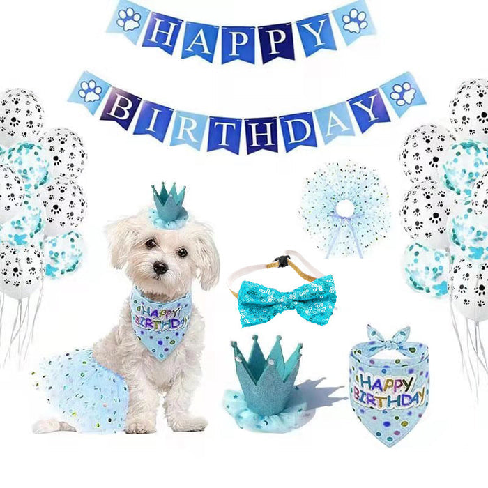 White small dog wearing a blue birthday crown and bandana with blue birthday party decorations.