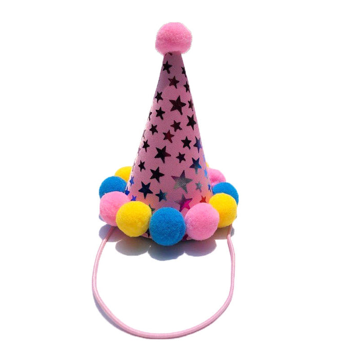 Pink star-patterned cone pet party hat with colorful pom poms and elastic strap