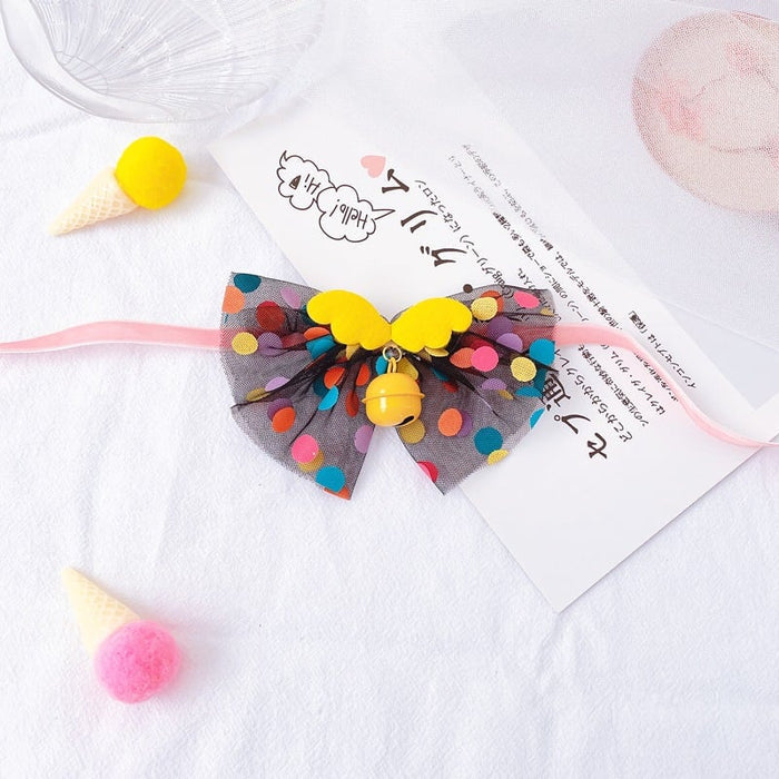 Colorful polka dot mesh pet bow tie with yellow butterfly accents and a small gold bell.