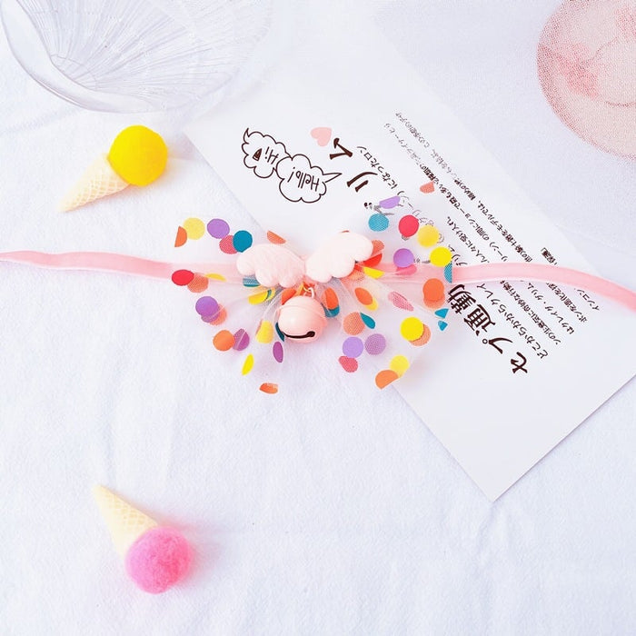 Colorful pet collar accessory with pastel pom poms, bells, and decorative confetti dots.