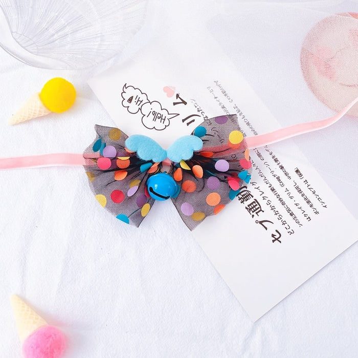 Colorful polka dot bow headband with blue wings and a bell for pets.