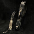 Stylish black leather dog leash with white stitching, metal spikes, and carbon fiber handle for pets