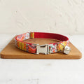 Colorful patterned cat collar with bell and metal buckle on wood, pet accessory for cats