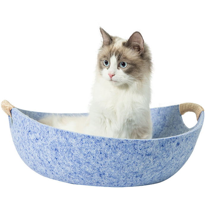 Fluffy cat in blue felt pet bed with rope handles, cozy cat accessory for comfort